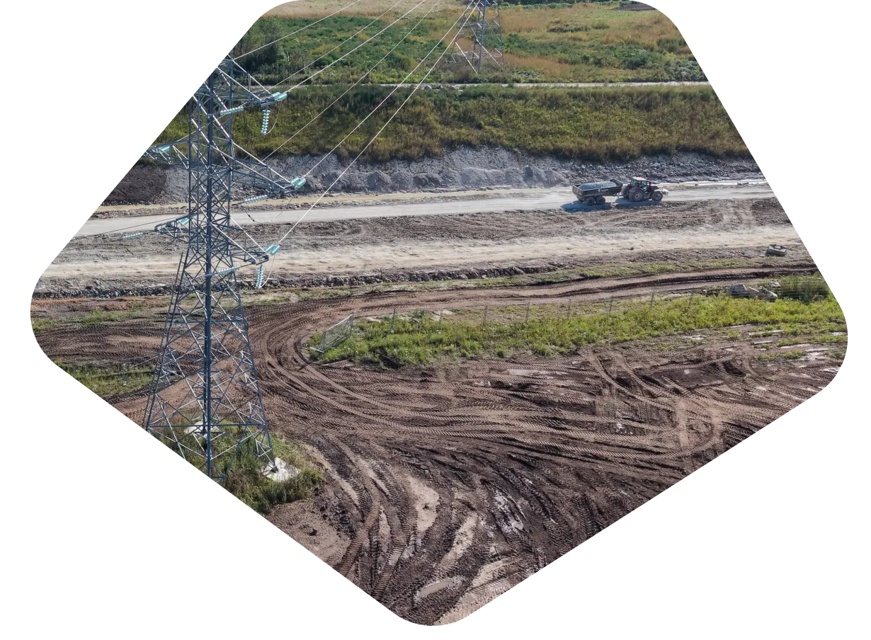 Aerial view of a construction site with cranes and excavators working on the foundations