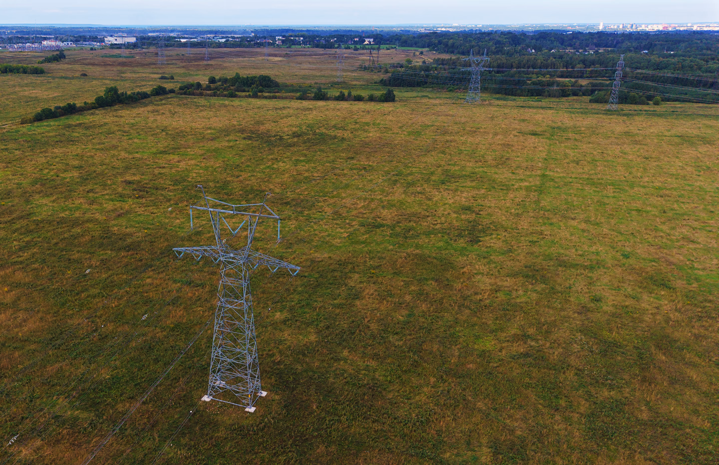 Aerial view of a transmission pylon in open farmland